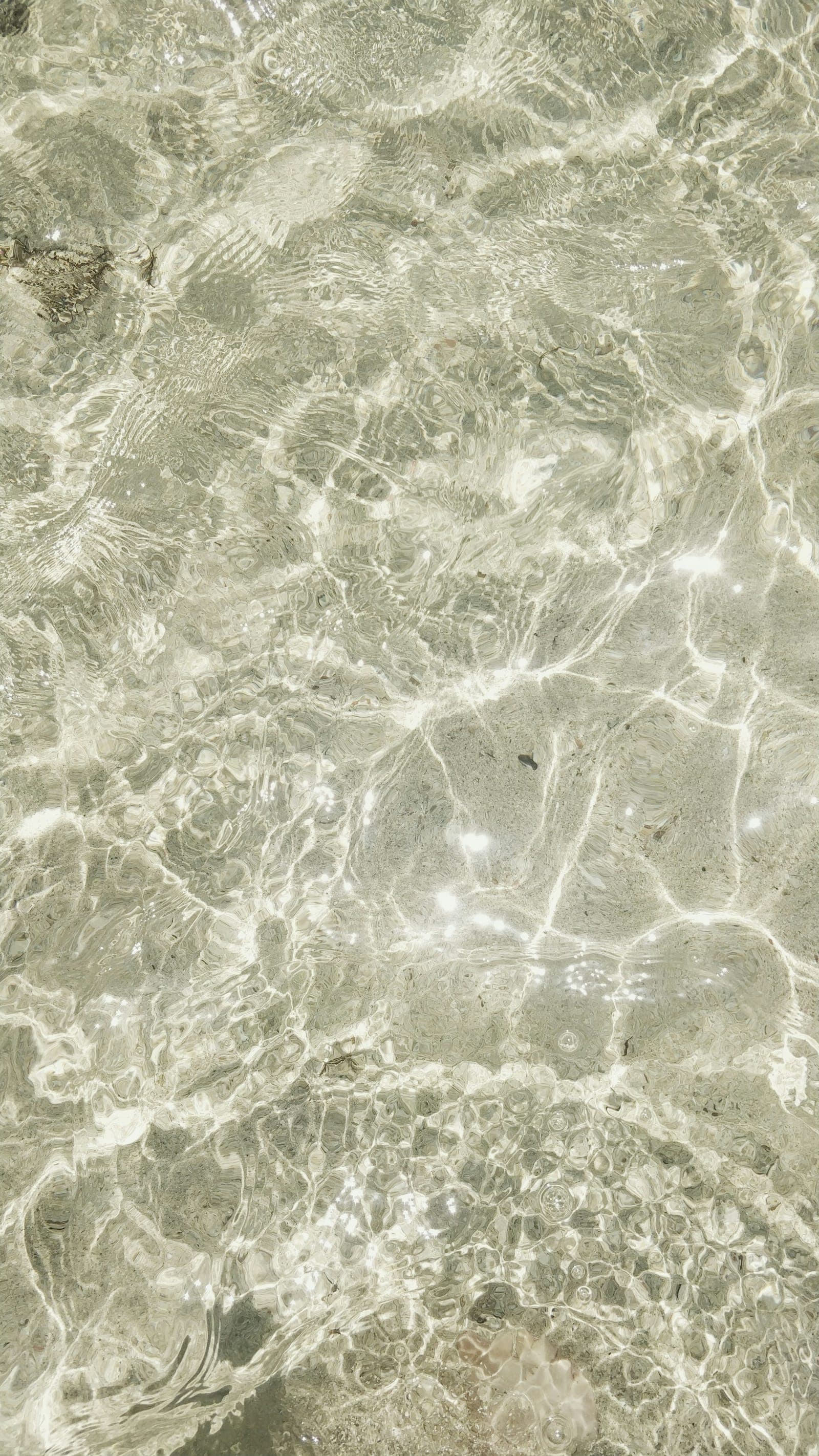 Clear shallow water over pale stone